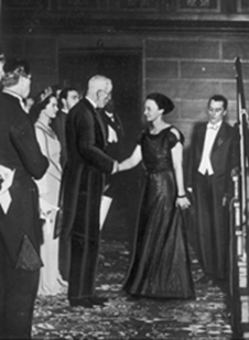 Król Szwecji Gustav V wręcza Nagrodę Nobla Irenie Joliot-Curie za nią stoi Fryderyk Joliot-Curie.