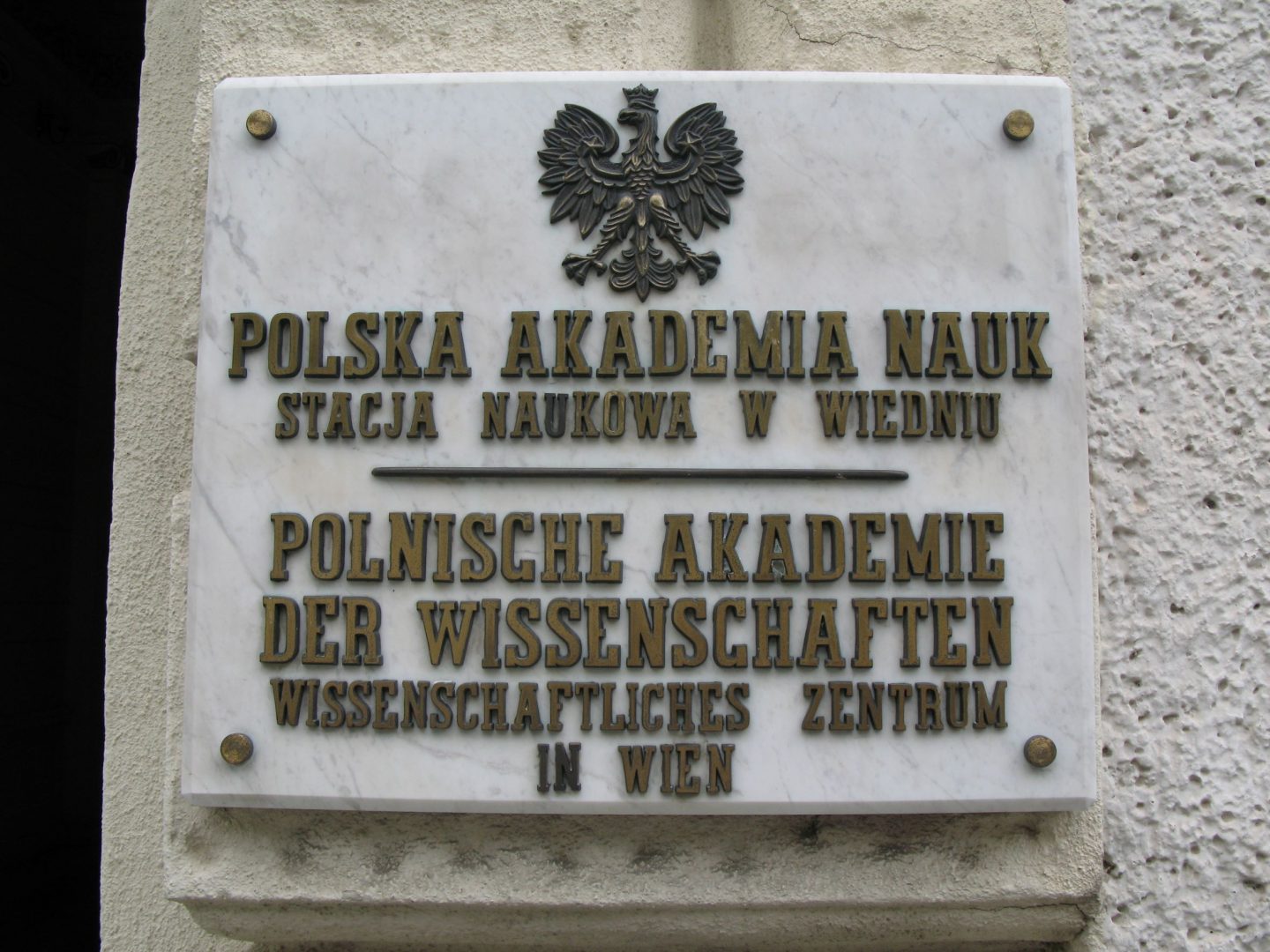 Marmurowa tablica z nazwą Stacji PAN w Wiedniu po polsku i niemiecku