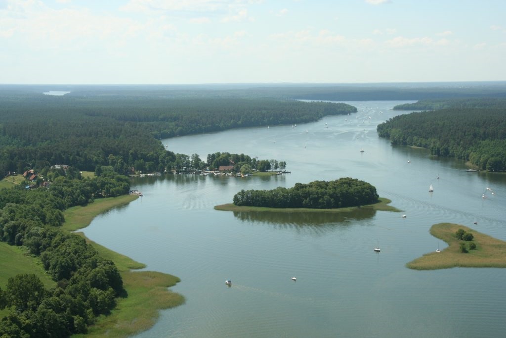 Widok z lotu ptaka na długie jezioro otoczone lasem