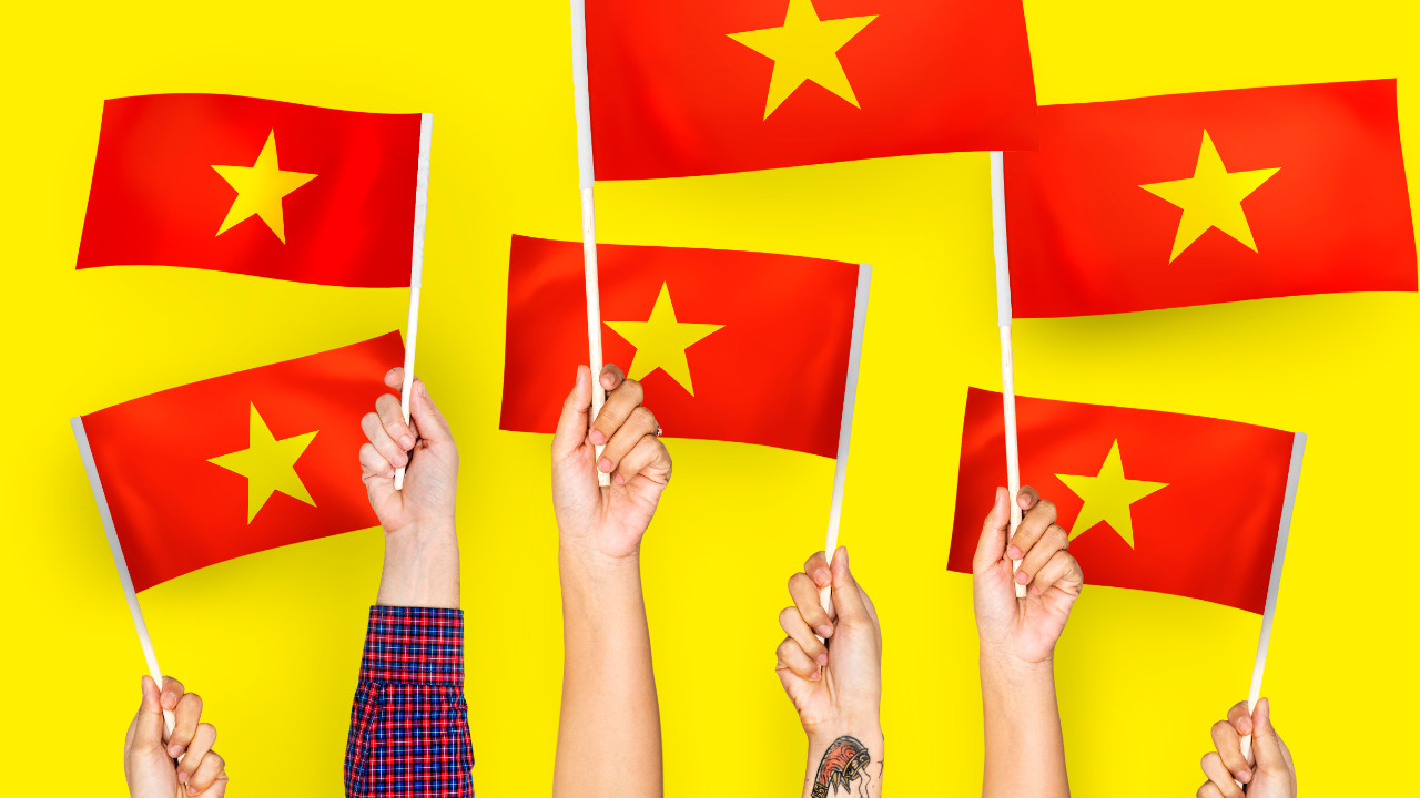 Ręce trzymające flagi wietnamskie