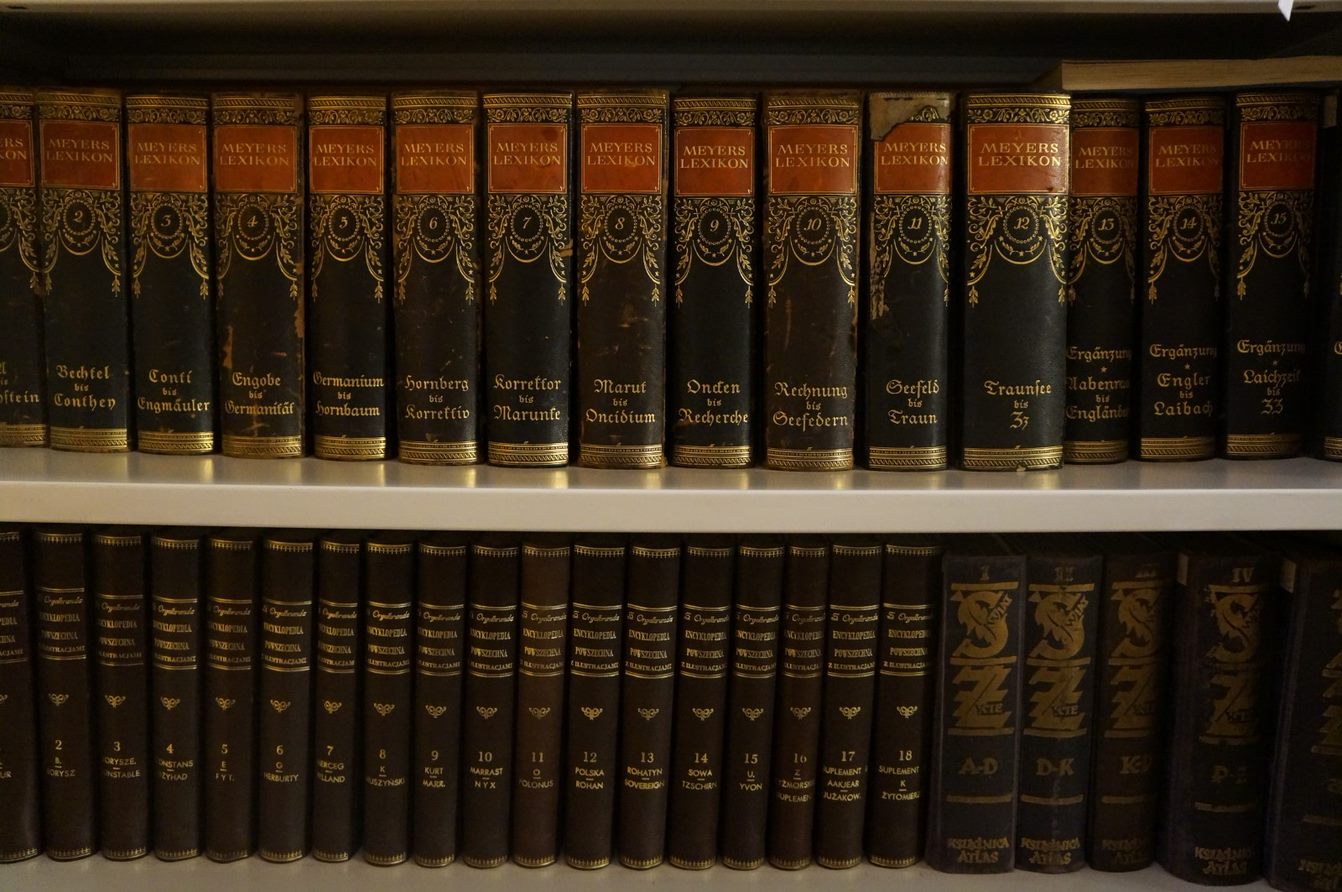 Książki w starych okładkach ustawione na półce