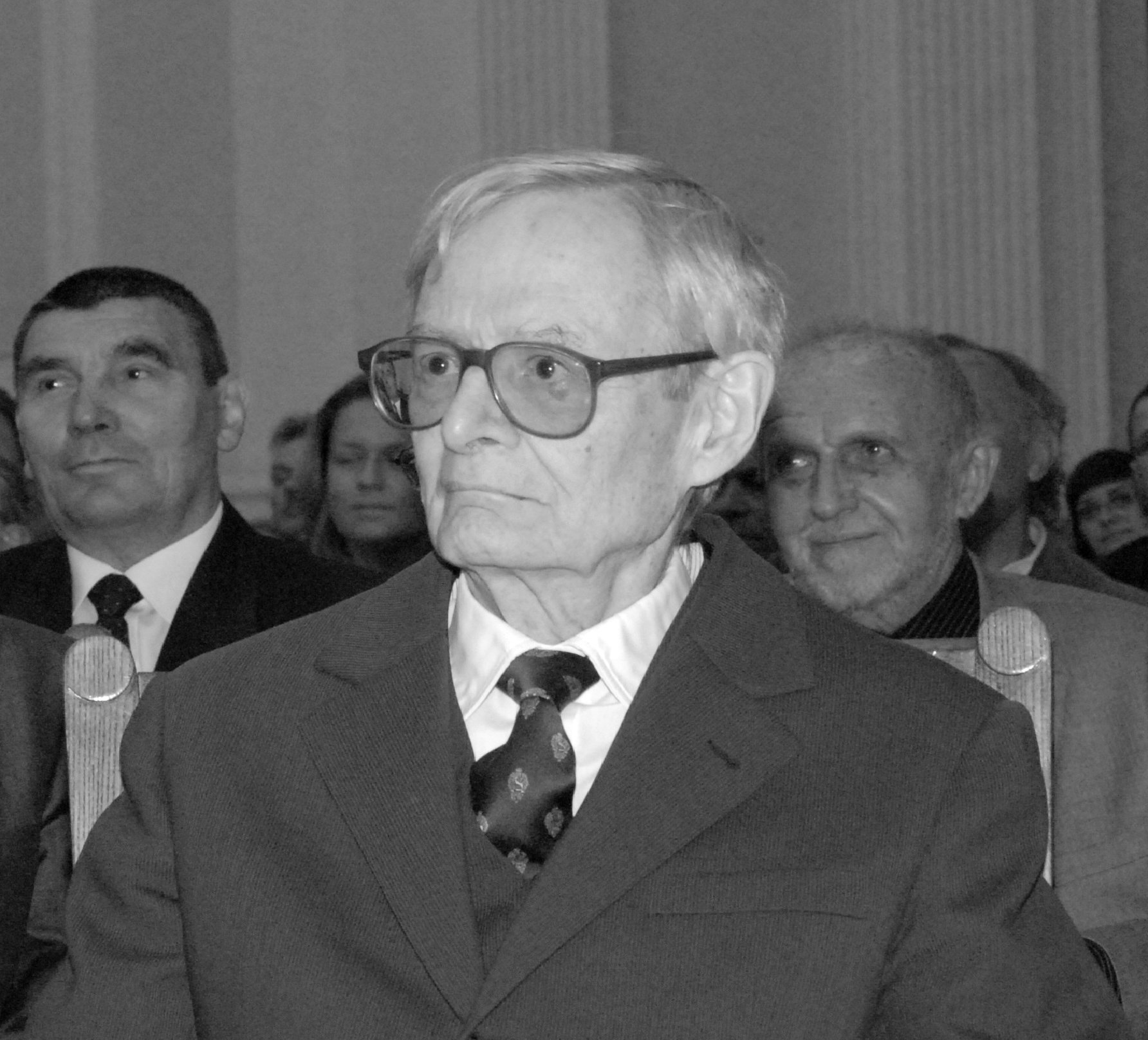 Starszy mężczyzna w garniturze i okularach w czerni i bieli